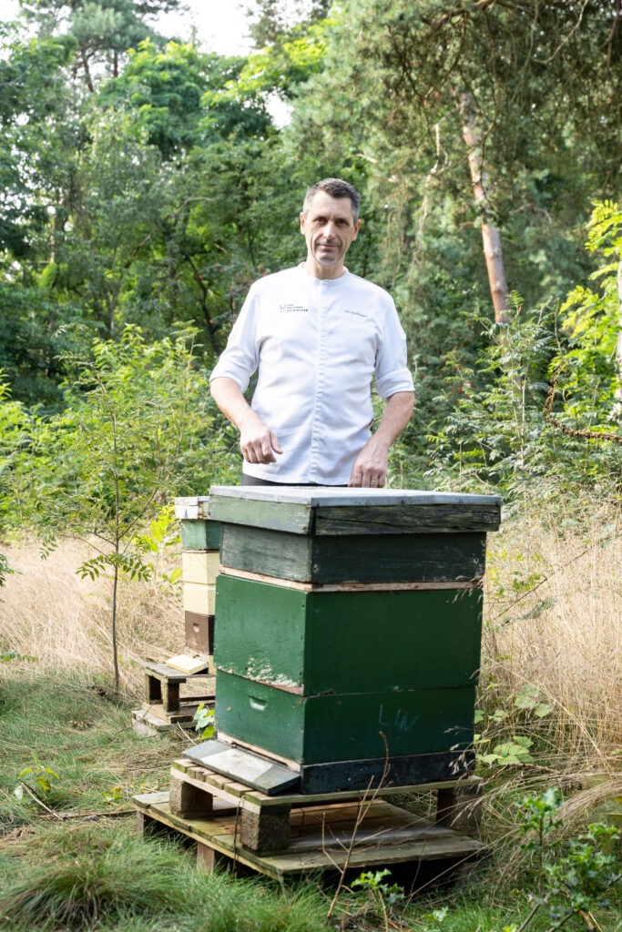 Erik de Mönnink bij een bijenkast.